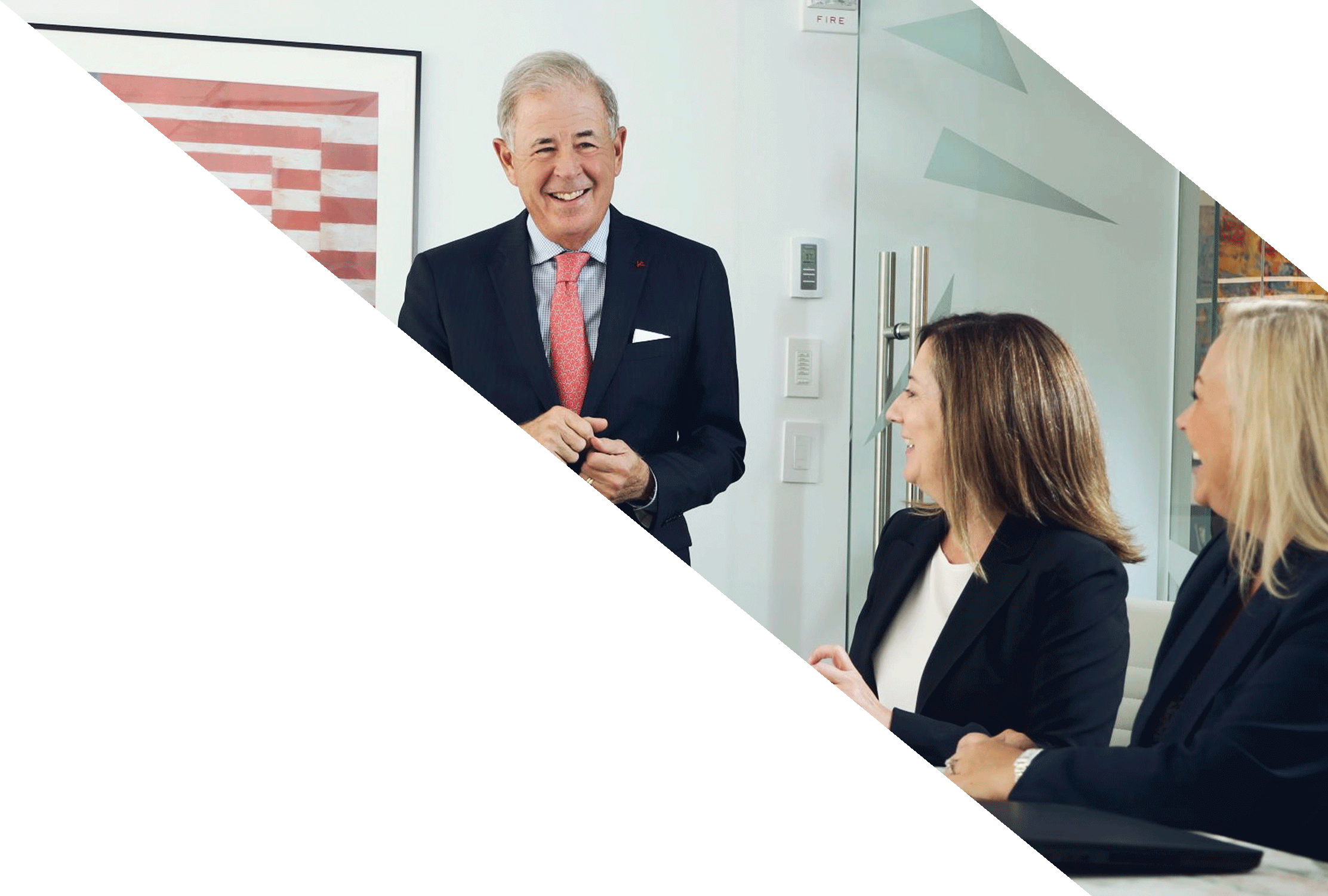 A business man stands laughing in front of a group gathered around a conference table, likely discussing topics such as escrow services, corporate actions, and corporate escrow support.