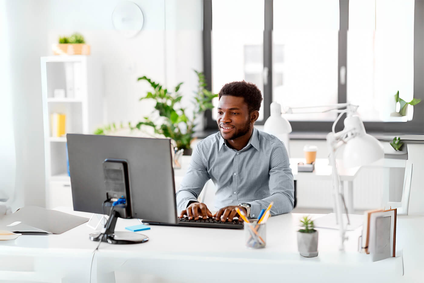 A man working at a laptop in an office setting, likely handling tasks related to Issuer Services and managing Abandoned Property.