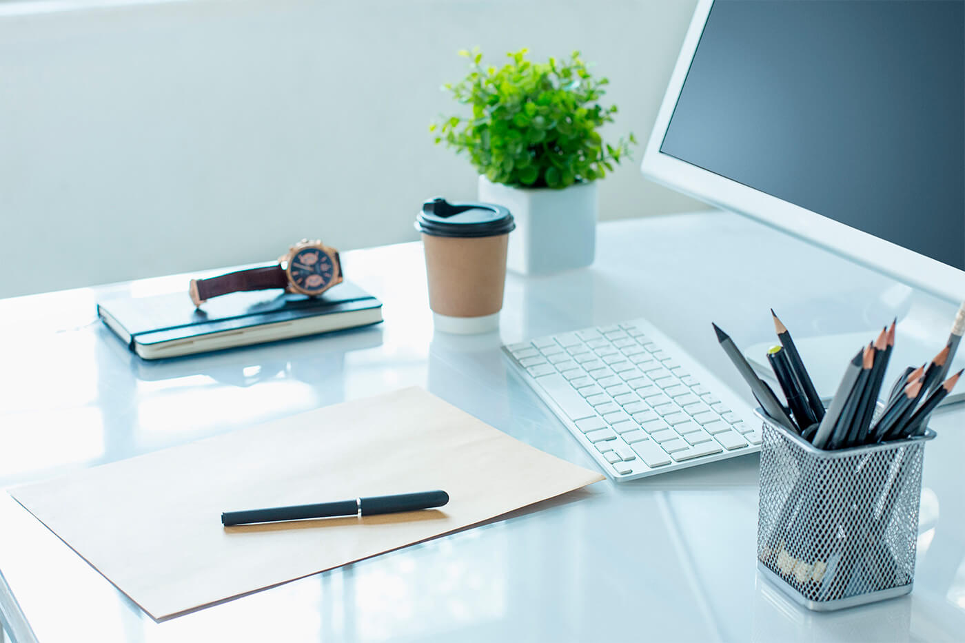 A desk featuring a computer and an envelope with a pen on it, possibly indicative of discussions or actions related to Rule 144 and Restricted Securities.